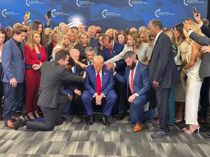 Group Prayer Around Seated Man