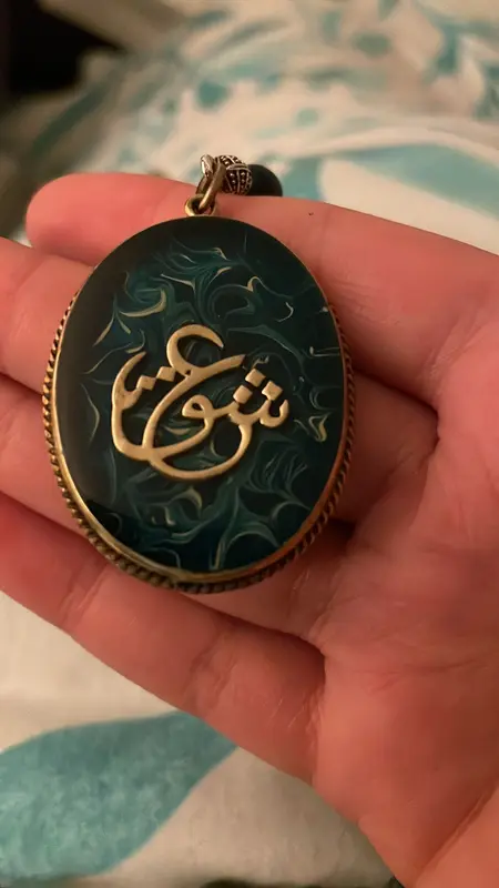 Hand Holding Blue Pendant