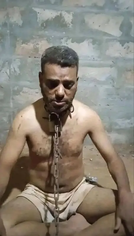 Man Chained, Sitting, Looking Down.