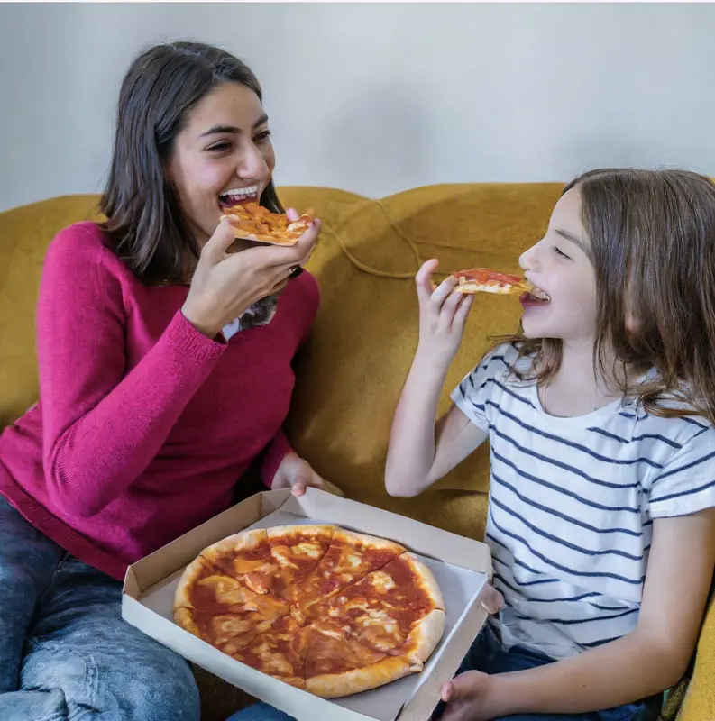 Mother And Daughter Eating Pizza