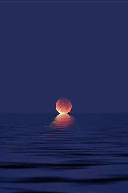 Red Moon Reflecting On Ocean