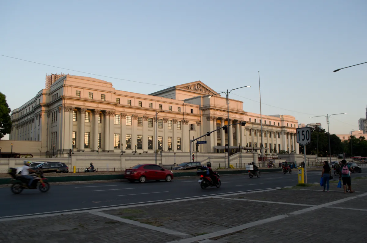 The National Museum of Fine Arts in Manila at sunset, with a tall tower visible behind the left wing of the building
